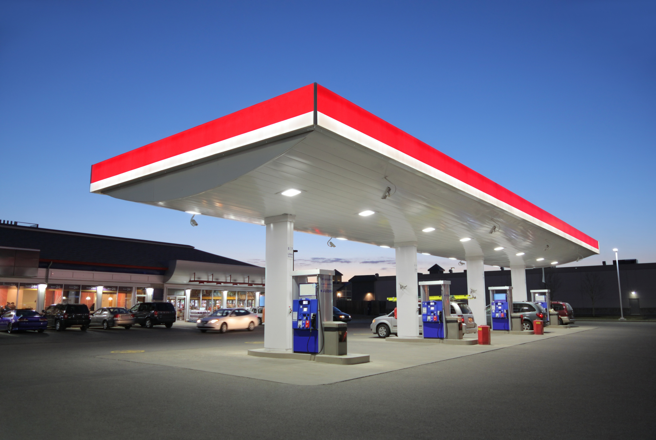 Illuminated fuel station forecourt and canopy fascia at dusk